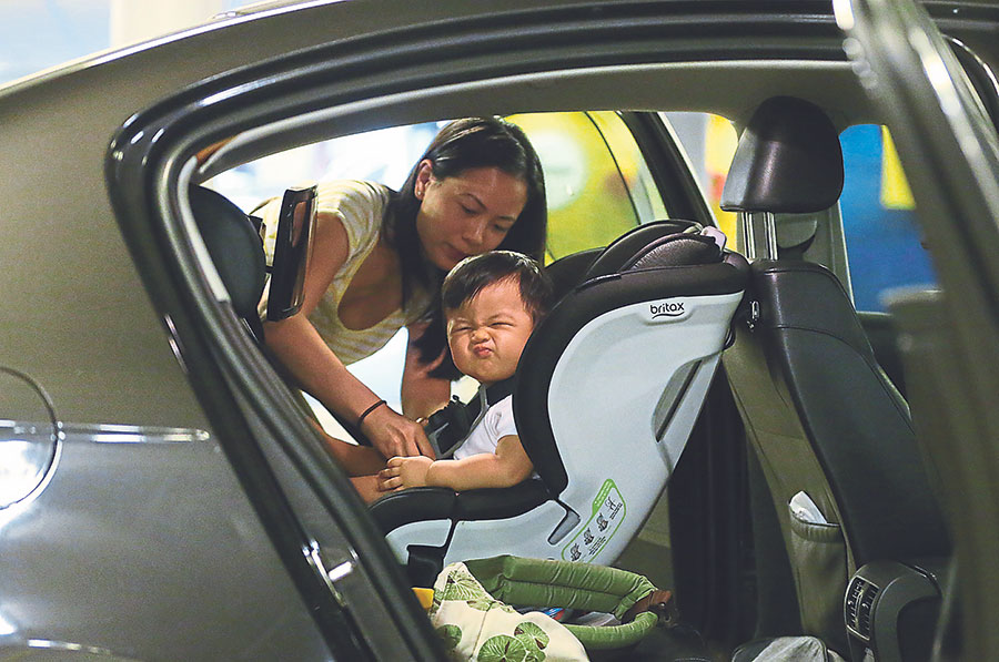 Nessa Liu straps one-year-old son Nathaniel Tan in a child safety seat. She says such seats should be made mandatory. u00e2u20acu201d Picture by Zuraneeza Zulkifli