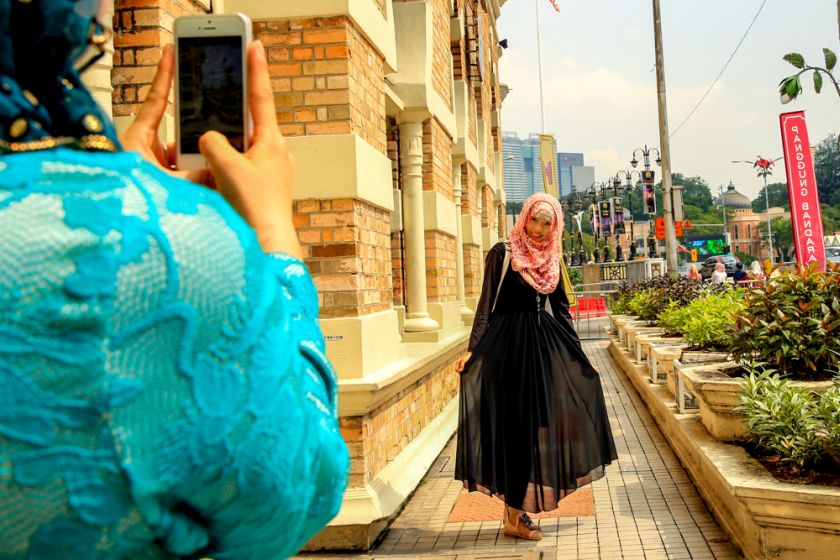 A China Muslim tourist poses for pictures at Dataran Merdeka, Kuala Lumpur, May 13, 2015. u00e2u20acu2022 Picture by Saw Siow Feng