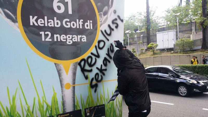 A protestor is seen vandalising a sign in a photo purportedly taken during today's rally, as seen on the official Facebook page of the Royal Malaysian Police. 
