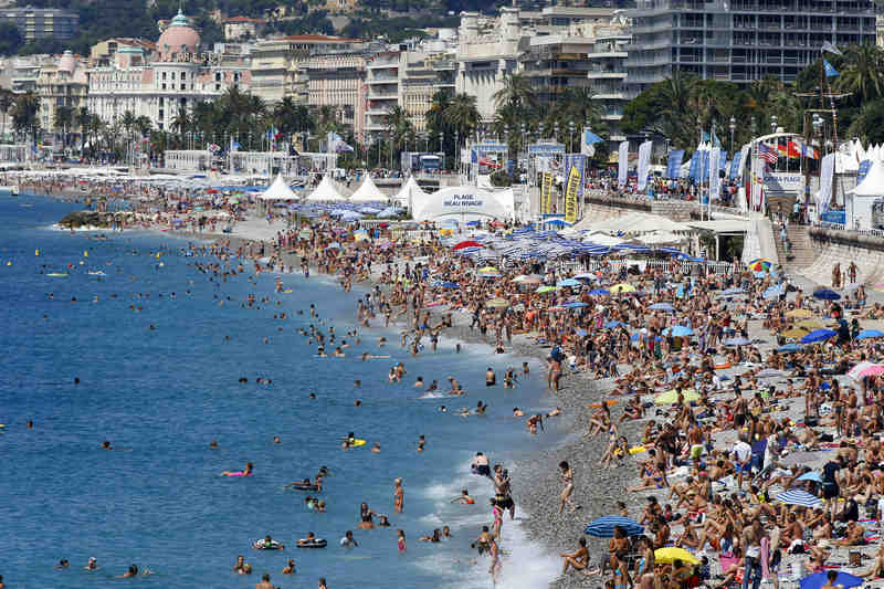 Holiday goers sunbathe on the beach in Nice, southeastern France. A group of more than 6,000 Chinese visitors ended their company trip to France in this resort town with a world record, May 9, 2015. u00e2u20acu201d AFPpic