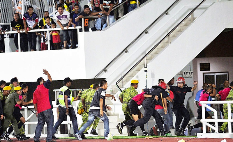Federal Reserve Unit personnel shield match officials as they are rushed to the dressing room after the return leg FA Cup semifinal on Saturday. u00e2u20acu201d Picture by Bernama