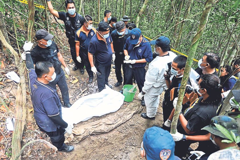 The grisly task of exhuming human remains at Bukit Wang Burma continues. u00e2u20acu201d Malay Mail pic