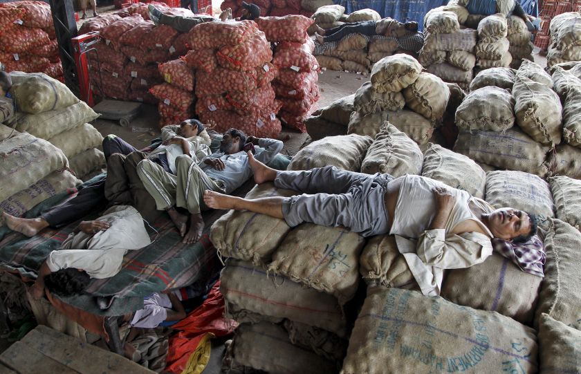 Vendors take a nap on stacked sacks of vegetables at a wholesale market on a hot summer day in Chandigarh, India, May 29, 2015. u00e2u20acu2022 Reuters pic
