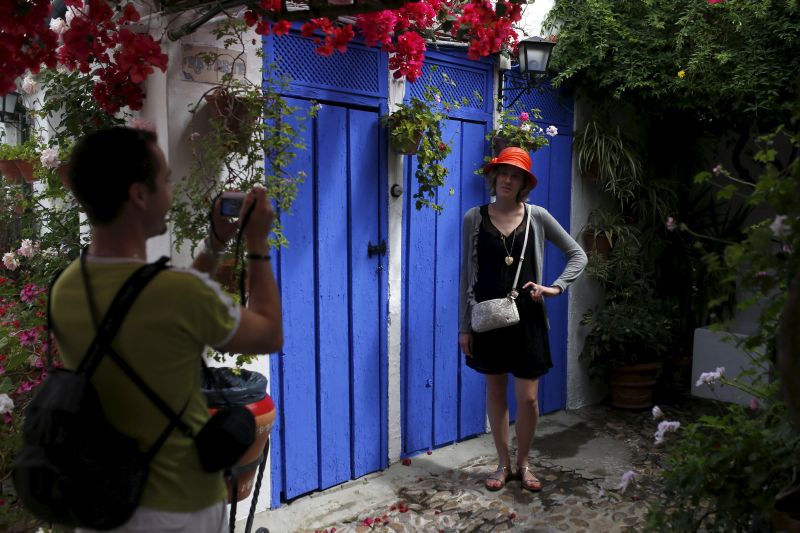 A tourist poses in a courtyard adorned with flowers during the Los Patios festival in Cordoba, southern Spain, May 7, 2015. u00e2u20acu2022 Reuters pic