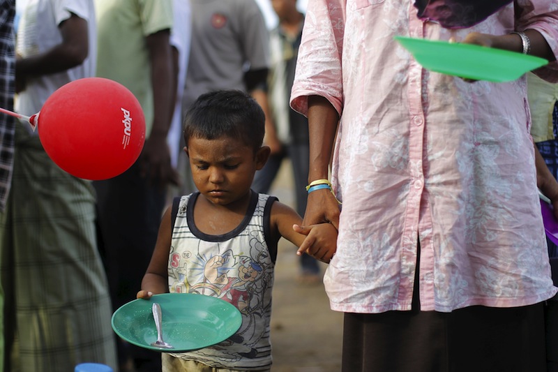 A Rohingya migrant, who arrived in Indonesia by boat, holds her child's hand as they wait for breakfast inside a temporary compound for refugees in Kuala Cangkoi village in Lhoksukon, Indonesia's Aceh Province May 17, 2015. u00e2u20acu201du00c2u00a0Reuters pic