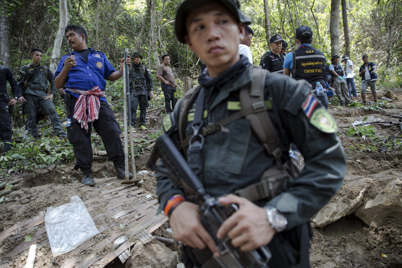 Thai security forces and rescue workers watch as human remains are retrieved from a mass grave at an abandoned camp in a jungle some three hundred metres from the border with Malaysia, in Thailand's southern Songkhla province May 2, 2015. u00e2u20acu201d Reuters pic
