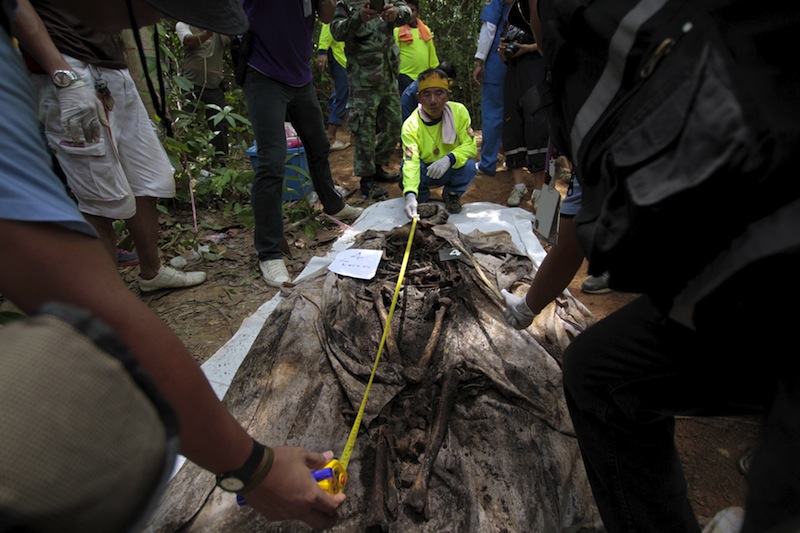 Rescue workers and forensic experts measure human remains retrieved from a mass grave at a rubber plantation near a mountain in Thailand's southern Songkhla province May 6, 2015. u00e2u20acu201du00c2u00a0Reuters pic