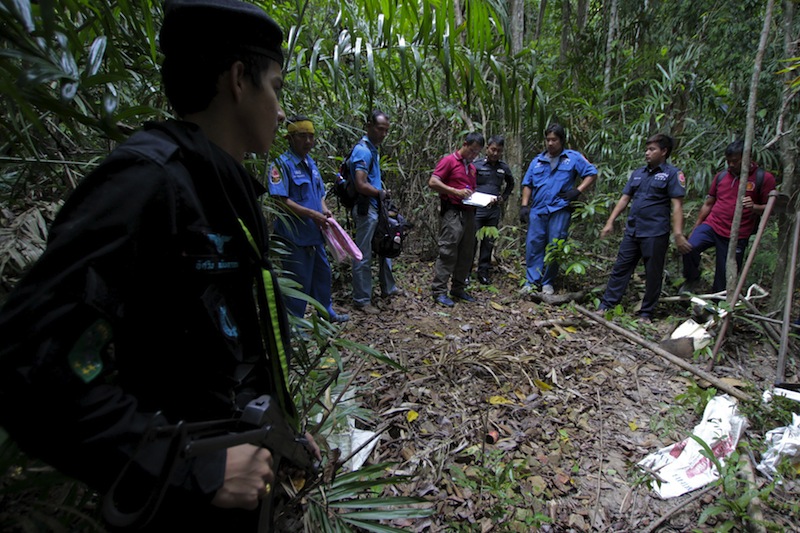 Security forces and rescue workers inspect a mass grave at a rubber plantation near a mountain in Thailand's southern Songkhla province May 7, 2015. u00e2u20acu201d Reuters pic