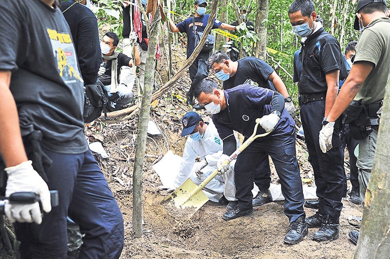 The forensic team carries out the grisly work of exhuming the graves.