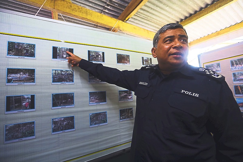 Khalid points to pictures of mass graves and migrants u00e2u20acu02dcprison campsu00e2u20acu2122. He says the priority of the police is to identify the people responsible for human trafficking along the Malaysia-Thai border. u00e2u20acu201d Picture by Sayuti Zainudin
