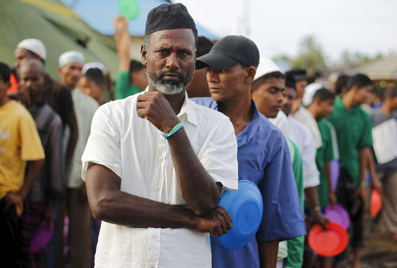 Rohingya migrants stand in line with plates for breakfast in Kuala Cangkoi village in Indonesia's Aceh Province May 17, 2015. u00e2u20acu201d Reuters picn
