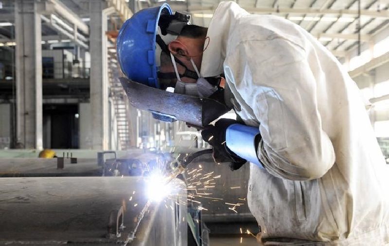 An employee welds the exterior of a vehicle along a production line at a factory in Qingdao, Shandong province, December 1, 2014. REUTERS/China Daily