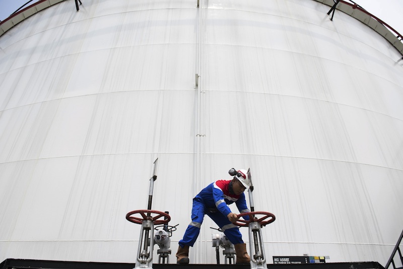 A worker at state-owned oil and gas company Pertamina checks the capacity of a fuel tank at a depot in Jakarta, Indonesia, in this April 15, 2015 file photo taken by Antara Foto. u00e2u20acu201d Reuters pic