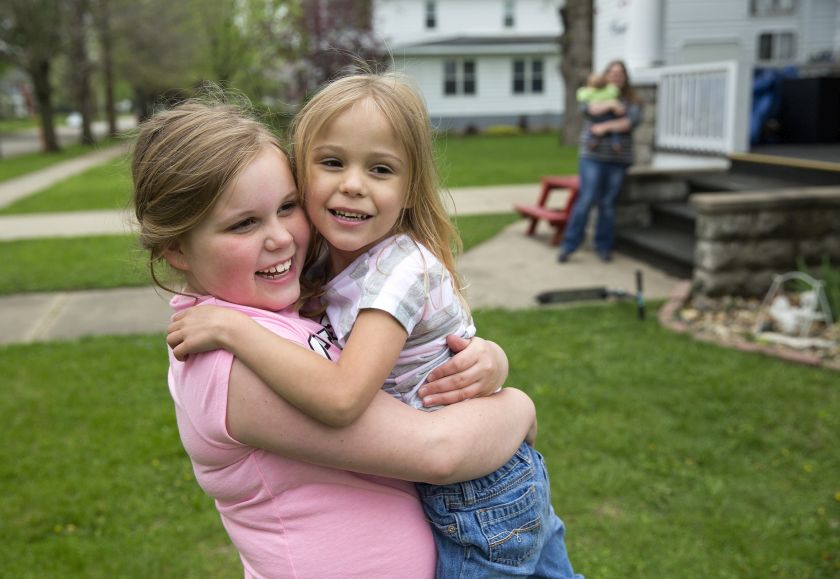 Alexis Hutchinson, right, a thriving five-year-old who was born prematurely at 22 weeks, hugs her sister Joslyn, 9, at home in Manchester, Iowa, May 5, 2015. — NYT pic
