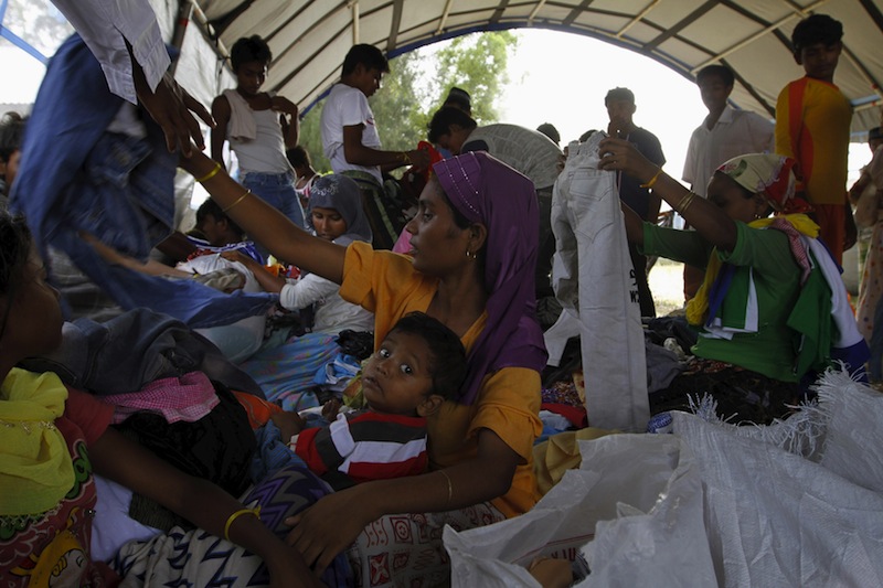 A Rohingya migrant and her child, who recently arrived in Indonesia by boat, search through donated clothing at a shelter in Kuala Langsa, in Indonesia's Aceh Province, May 17, 2015. u00e2u20acu201d Reuters pic