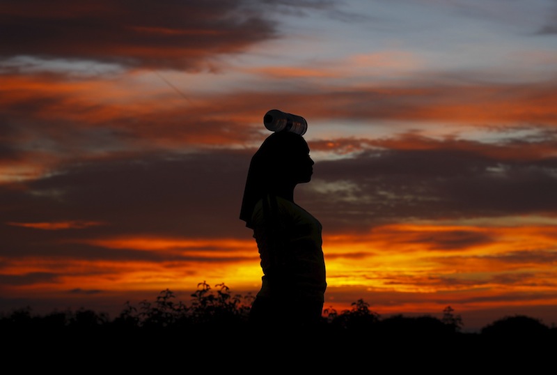 A Rohingya migrant woman, who arrived in Indonesia by boat, carries a bottle of drinking water as she walks inside a temporary compound for refugees in Kuala Cangkoi village in Lhoksukon, Indonesia's Aceh Province May 17, 2015.u00c2u00a0u00e2u20acu201d Reuters pic
