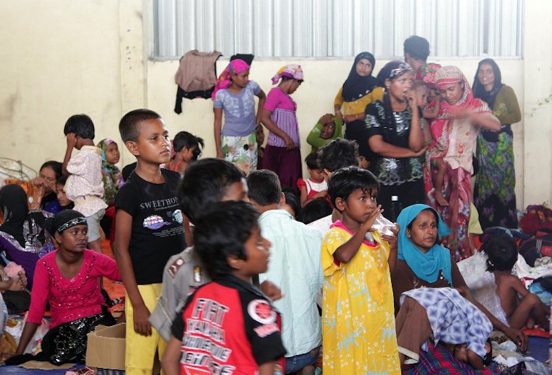 A group of rescued women and children migrants, mostly Rohingya from Myanmar and Bangladesh, gather upon their arrival at the new confinement area in the fishing town of Kuala Langsa in Aceh province May 15, 2015. u00e2u20acu201d AFP pic