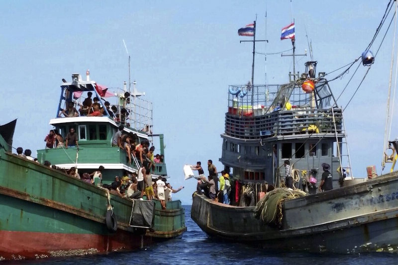 Thai fishermen (right) give some supplies to migrants on a boat drifting 17km off the coast of the southern island of Koh Lipe, Thailand May 14, 2015. u00e2u20acu201d Reuters pic