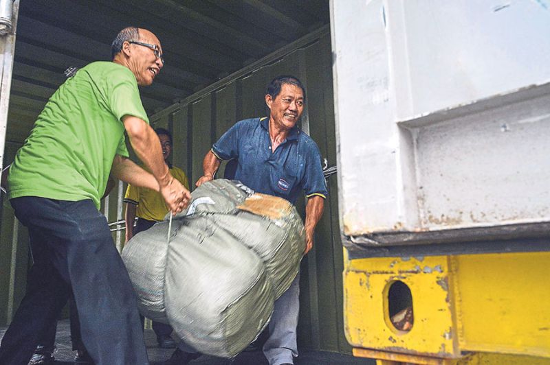Volunteers load goods into containers for Rohingya boat people yesterday. The Sentul Police District headquarters was turned into a collection hub by several charity groups. u00e2u20acu201d Picture by Firdaus Latif