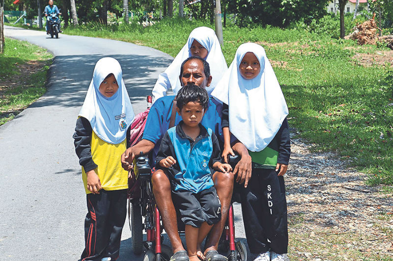 Rosli and his children stop for a photograph on the way home from school.