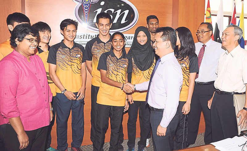 Shakila shakes hands with Chef de Mission Datuk Seri Mohamad Norza Zakaria during a meeting with Games athletes at the National Sports Institute on April 24, 2015. u00e2u20acu201d File picture