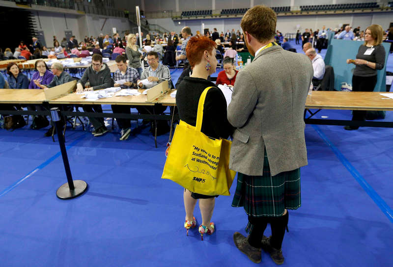 Party workers, one carrying a Scottish National party bag, watch ballots being tallied after polls closed in Britain's general election in Glasgow, May 7, 2015.  u00e2u20acu201d Reuters pic 