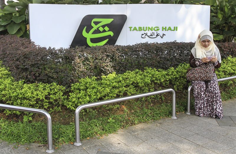 A woman plays with her smartphone in front of the Tabung Haji Building in Kuala Lumpur, May 10, 2015. u00e2u20acu2022 Picture by Yusof Mat Isa