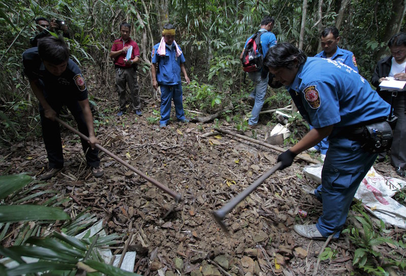 Security forces and rescue workers inspect a mass grave at a rubber plantation near a mountain in Thailand's southern Songkhla province May 7, 2015. u00e2u20acu201d Reuters pic