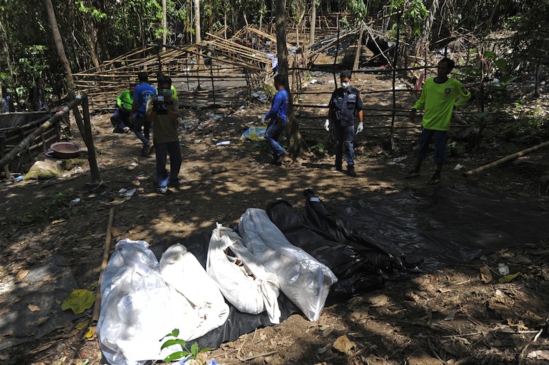 Bags containing skeletons dug out from shallow graves lay on the ground at the site of a mass grave at an abandoned jungle camp in the Sadao district of Thailand's southern Songkhla province bordering Malaysia on May 2, 2015. u00e2u20acu201d AFP pic