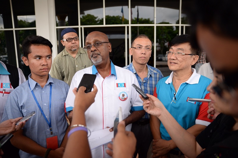 R. Sivarasa (centre), with Tian Chuau00e2u20acu2122s driver Mohd Huraimi Husni (left) and aide Chin Sin Pang (right), addresses the media at the Central Seberang Perai District Police headquarters in Penang, May 3, 2015. u00e2u20acu2022 Picture by K.E. Ooi