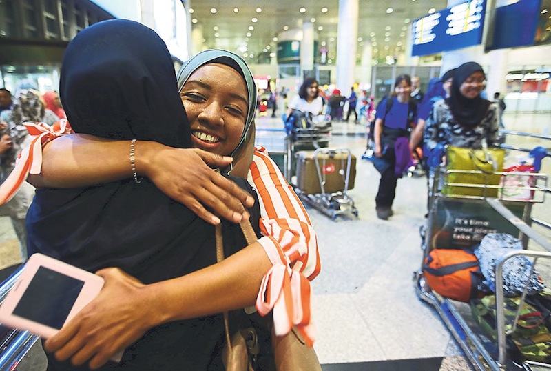 Zuraini hugging a relative on arrival at the Kuala Lumpur International Airport yesterday.