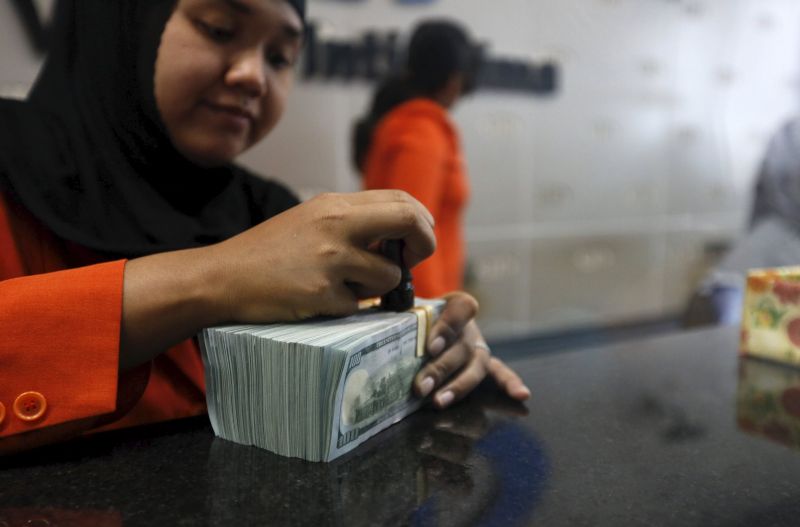 A teller handles US dollars at a money changer in Jakarta, Indonesia. u00e2u20acu2022 Reuters pic