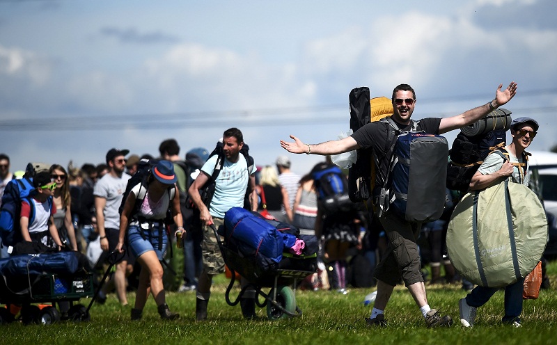 Revellers carry their belongings as they arrive for the Glastonbury Festival at Worthy Farm in Somerset, Britain, June 24, 2015. — Reuters pic