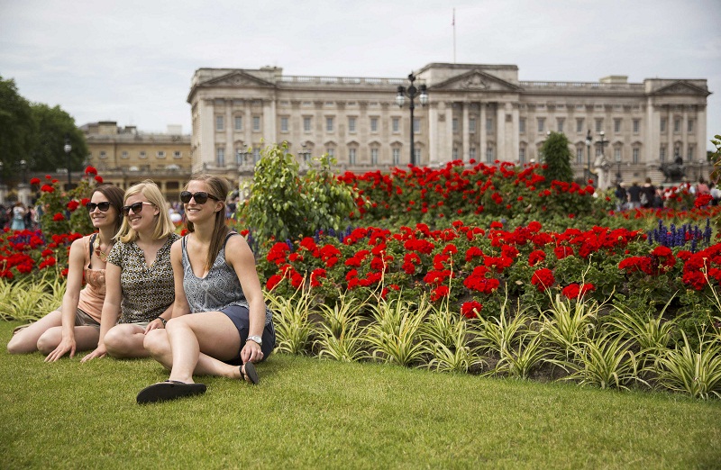Tourists pose as a friend photographs them in front of Buckingham Palace during hot weather in central London, Britain June 30, 2015. — Reuters pic