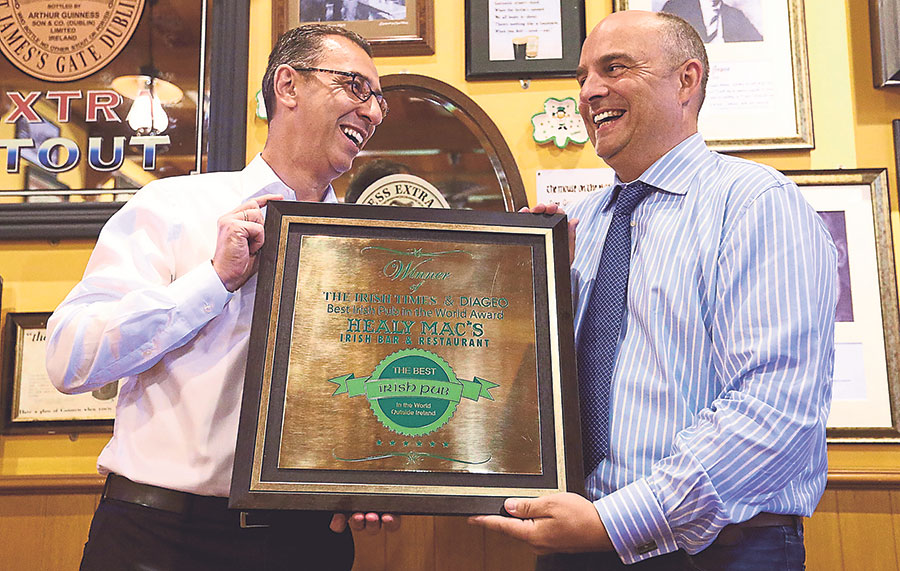 Healy (right) accepts the award for ‘The Best Irish Pub in the World (Outside Ireland) from GAB managing director Hans Essaadi.