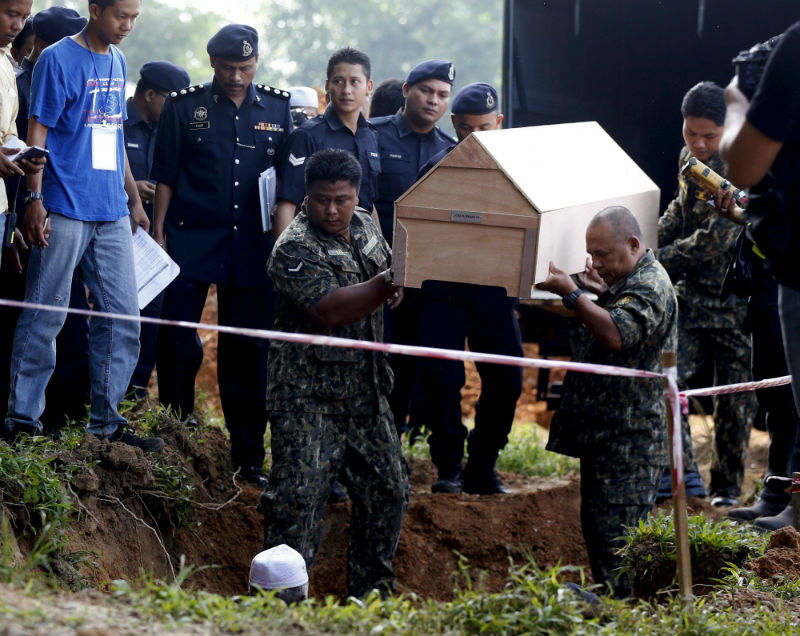 Malaysian police carry a coffin with unidentified remains of Rohingya people found at a traffickers camp in Wang Kelian last month, to be buried in a mass grave at a cemetery near Alor Star, Malaysia, June 22, 2015. — Reuters pic