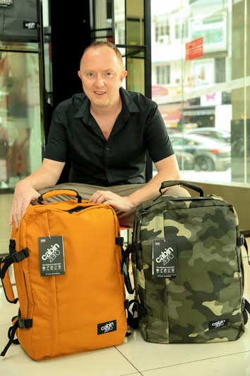 Neil Varden, founder of CabinZero bags, with the two top-selling bags, Orange Chill and Urban Camo.
