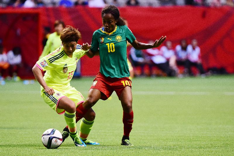 Japan forward Yuika Sugasawa (15) and Cameroon forward Jeannette Yango (10) battle for the ball. 
