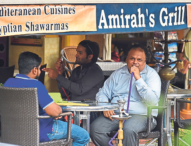 A customer smokes a shisha or “hookah” pipe at a cafe in Singapore on November 4, 2014. — AFP pic