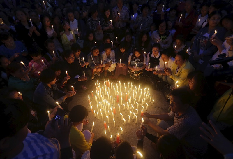 Local residents pray at a candlelight vigil to pay their respects to the victims of the sunken Eastern Star cruise ship on the Yangtze River, at a public square in Jianli, Hubei province, China, June 4, 2015. — Reuters pic