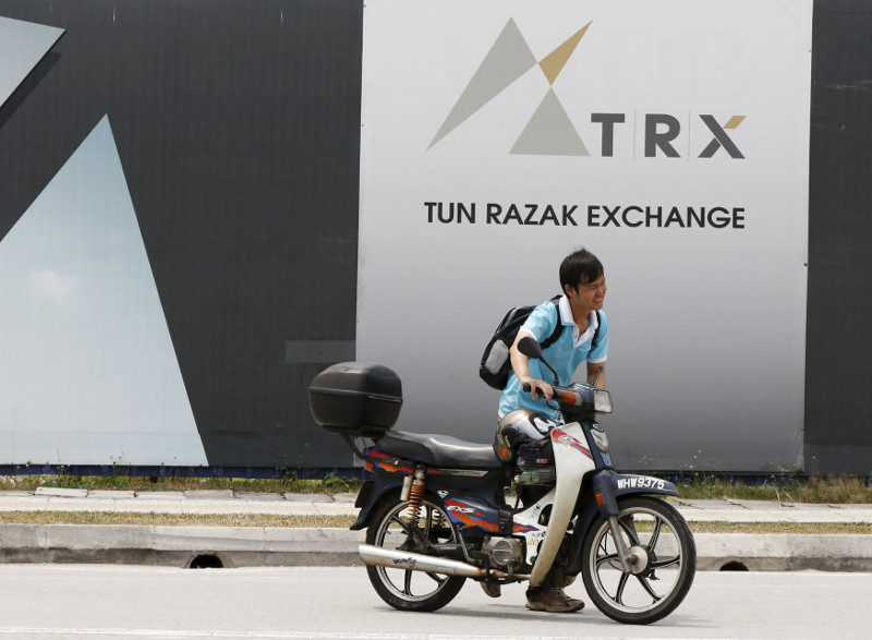 A man pushes his bike past 1Malaysia Development Berhad (1MDB) flagship Tun Razak Exchange development in Kuala Lumpur, July 3, 2015. u00e2u20acu201d Reuters pic