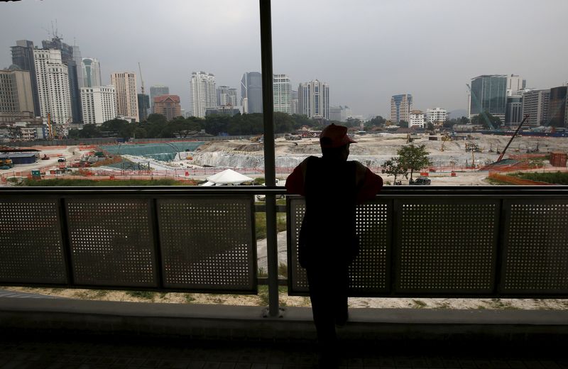 A man looks out at the 1 Malaysia Development Berhad flagship Tun Razak Exchange development in Kuala Lumpur, Malaysia, July 3, 2015. The ringgit and Malaysian equities took a battering July 6, 2015. u00e2u20acu201d Reuters picn