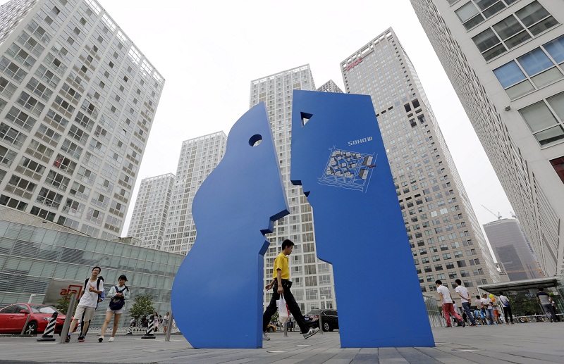People walk among office buildings in Beijing's central business district, July 15, 2015. u00e2u20acu201d Reuters pic