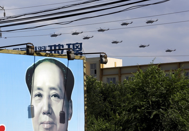 Military helicopters fly in formation above a billboard with a picture of Chinau00e2u20acu02dcs late Chairman Mao Zedong during a training session for the upcoming parade marking the 70th anniversary of the end of World War Two, on the outskirts of Beijing, July 2, 2