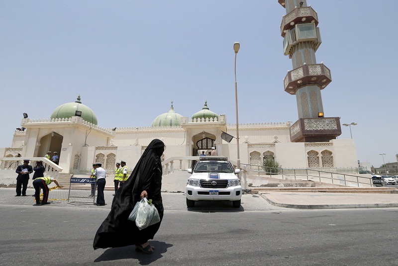 A woman walks in front of the Al Au00e2u20acu2122ali Grand Mosque as police set up security check points and block an area, where joint Sunni and Shiu00e2u20acu2122ites prayers are to be held to show solidarity and co-existence between the two sects of Islam, ahead of Friday pra