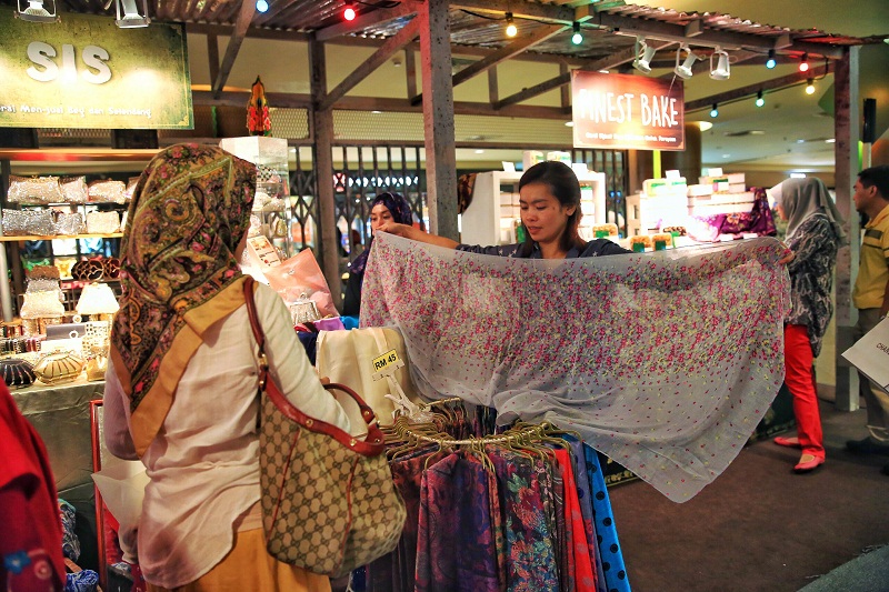 Two ladies shop for scarves at a makeshift traditional shop on display in Mid Valley megamall, in conjunction with the upcoming Hari Raya celebrations, in Kuala Lumpur, July 5, 2015. u00e2u20acu201d Picture by Saw Siow Feng