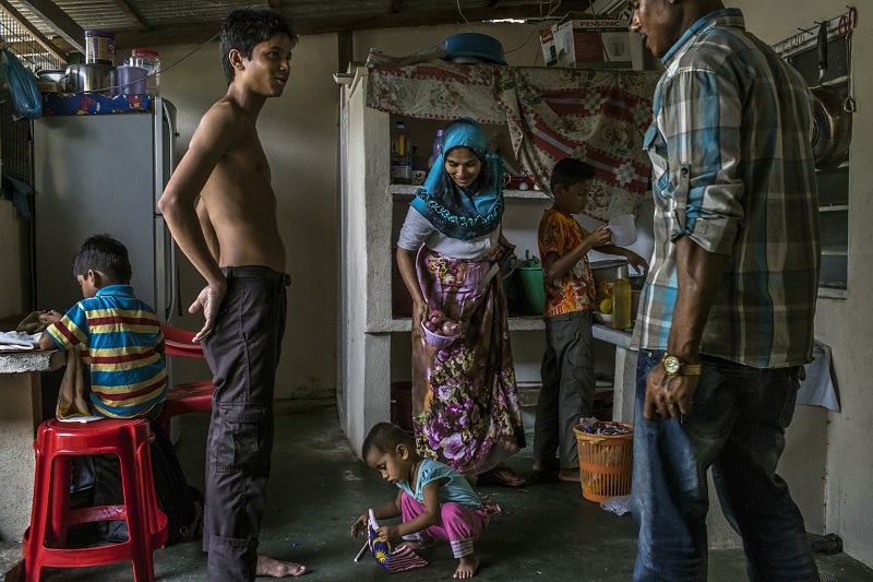 Hasinah Izhar (centre) who fled Myanmar and left her left her oldest son behind, with her family in the small, two-story house she shares with 13 other people, mostly Rohingya, in Gelugor, Malaysia, June 5, 2015. — Picture by Mauricio Lima for The New Y