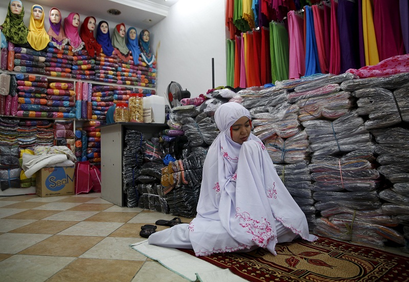 A woman prays inside a clothes shop at the Ramadan bazaar ahead of the Hari Raya Aidilfitri celebrations in Kuala Lumpur, July 14, 2015. u00e2u20acu201d Reuters pic