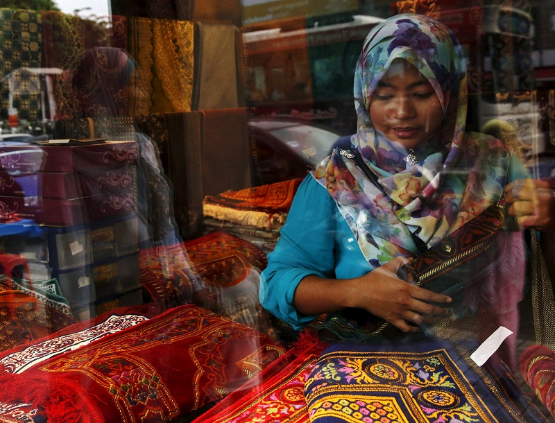 A woman shops for carpets at the Ramadan bazaar ahead of Hari Raya Aidilfitri celebrations in Kuala Lumpur, July 14, 2015. u00e2u20acu201d Reuters pic