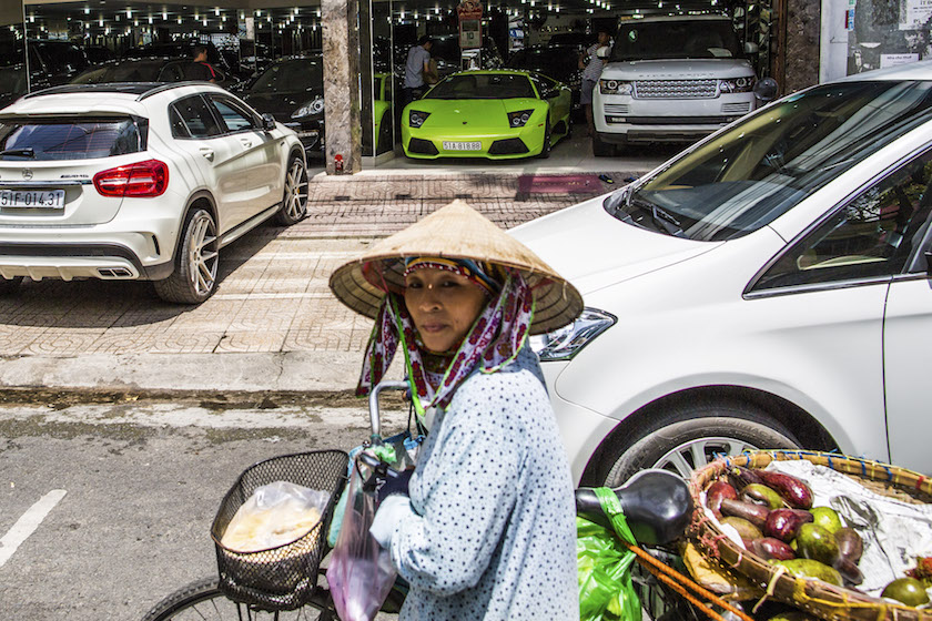 A woman passes a luxury car dealership in Ho Chi Minh City July 10, 2015. — Picture by Christian Berg/The New York Times